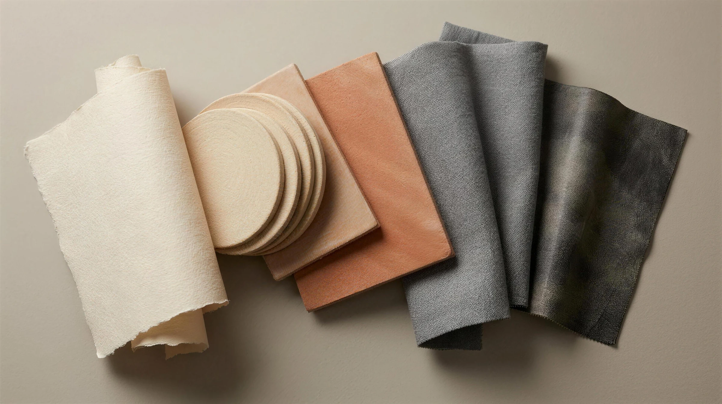 A spectrum of materials running from warm handmade paper and terracotta into cool linen and slate leather
